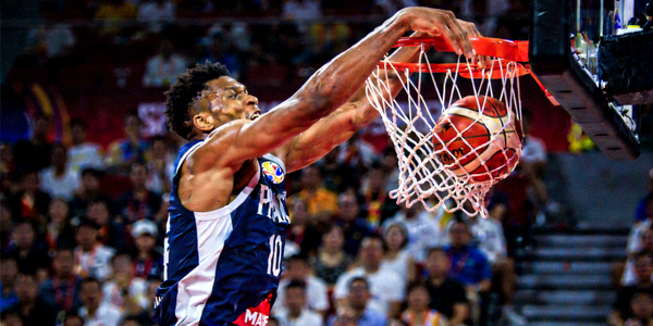 篮球世界杯比赛中球员完成精彩扣篮的瞬间，力量与技巧的完美结合