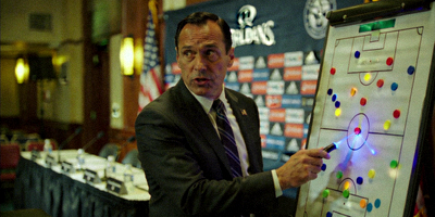 主教练在赛前发布会上讲解战术板，神情专注