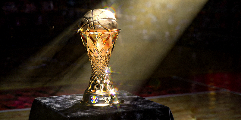 篮球世界杯冠军奖杯在聚光灯下熠熠生辉，象征着最高荣誉